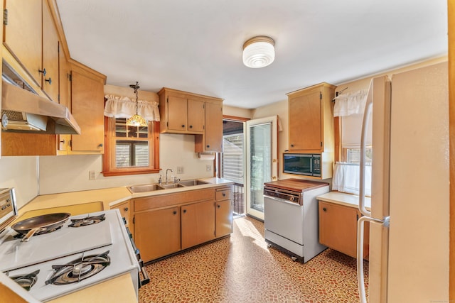 kitchen featuring white appliances, light floors, light countertops, under cabinet range hood, and a sink