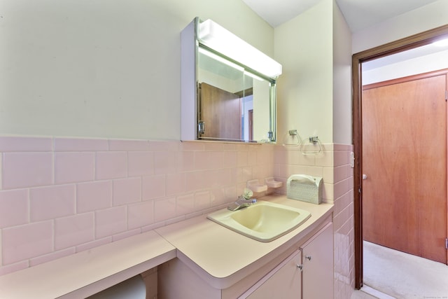 bathroom with vanity and tile walls
