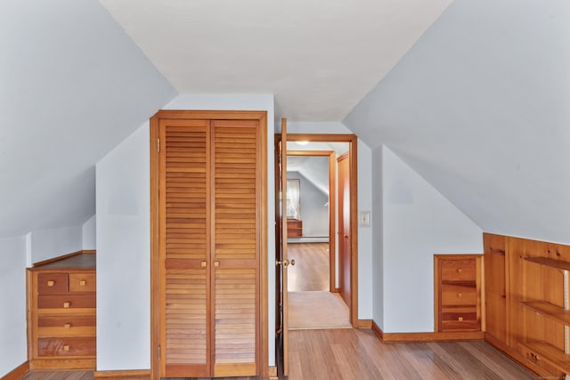 bonus room featuring baseboards, vaulted ceiling, and light wood-style flooring