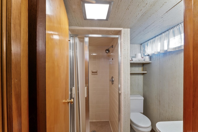 full bathroom featuring a stall shower and toilet