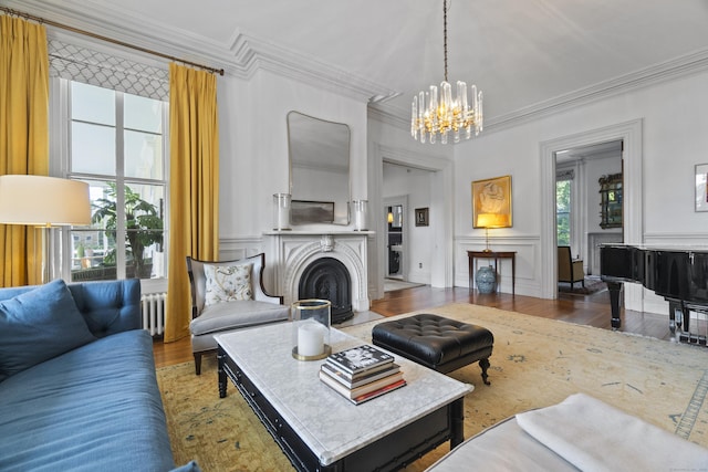 259 N Main St, Stonington, CT 06378 - living area featuring ornamental molding, radiator heating unit, a chandelier, wood finished floors, and a decorative wall