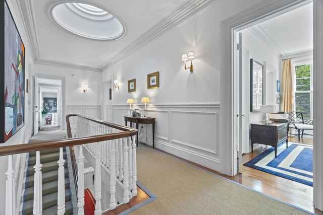 259 N Main St, Stonington, CT 06378 - hallway featuring an upstairs landing, ornamental molding, a wainscoted wall, and wood finished floors