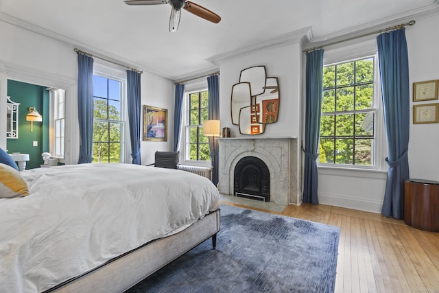 259 N Main St, Stonington, CT 06378 - bedroom featuring crown molding, a fireplace with flush hearth, radiator, wood-type flooring, and ceiling fan