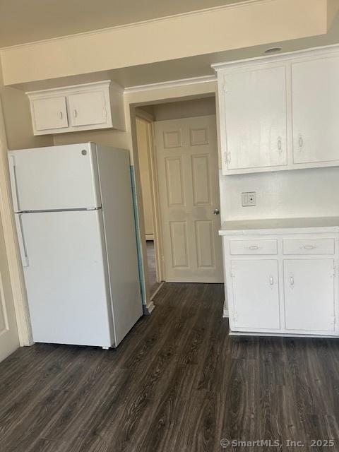 kitchen with freestanding refrigerator, white cabinetry, dark wood finished floors, and light countertops