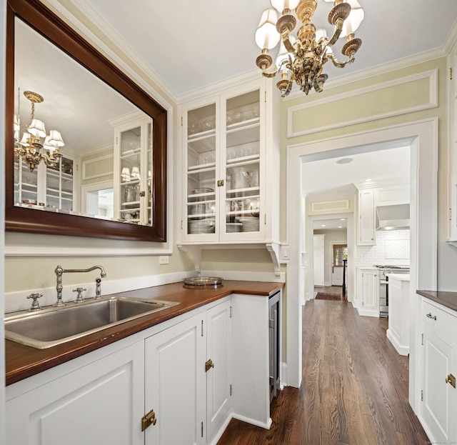 828 Sasco Hill Rd, Fairfield, CT 06824 - bar area with a chandelier, a sink, wall chimney range hood, dark wood-style flooring, and stainless steel range
