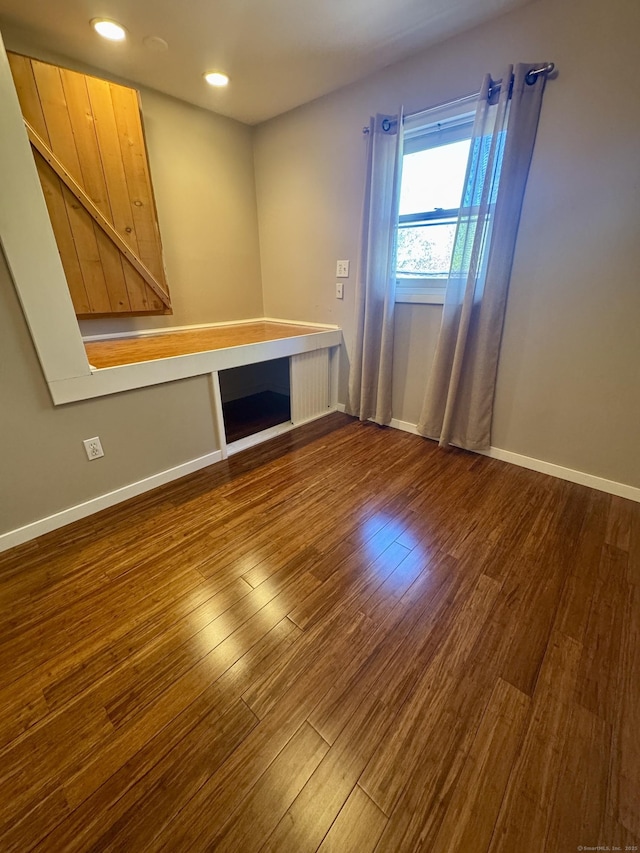 spare room with recessed lighting, baseboards, and dark wood-style floors