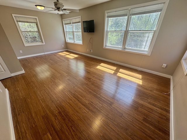 empty room with a ceiling fan, baseboards, and wood finished floors