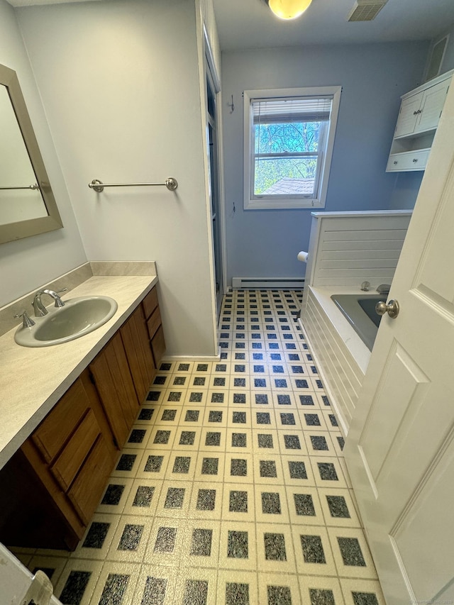 full bathroom with baseboards, baseboard heating, a garden tub, and vanity