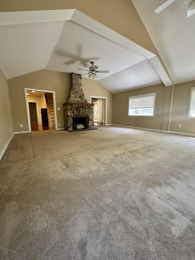 unfurnished living room with baseboards, a ceiling fan, lofted ceiling, and carpet flooring