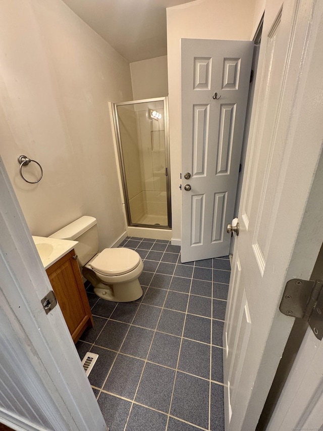bathroom with toilet, tile patterned floors, a shower stall, and vanity
