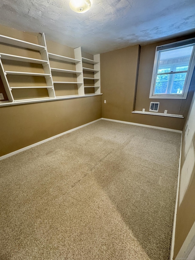 unfurnished room with baseboards, carpet floors, and a textured ceiling