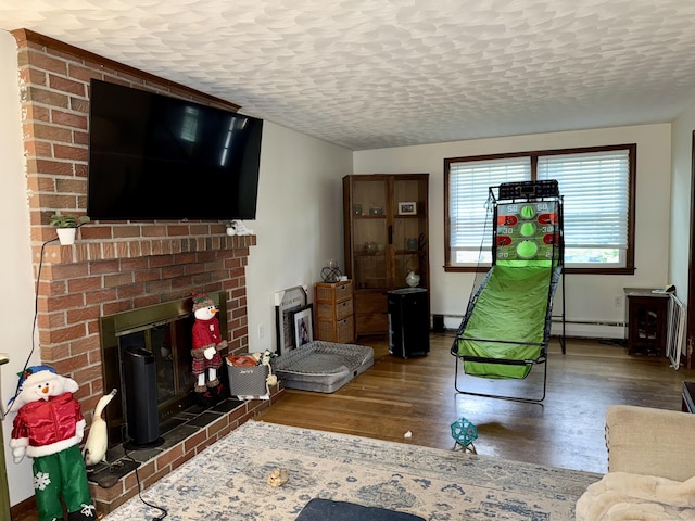 5 Hampton Rd, Enfield, CT 06082 - living area featuring a baseboard radiator, wood finished floors, a fireplace, and a textured ceiling