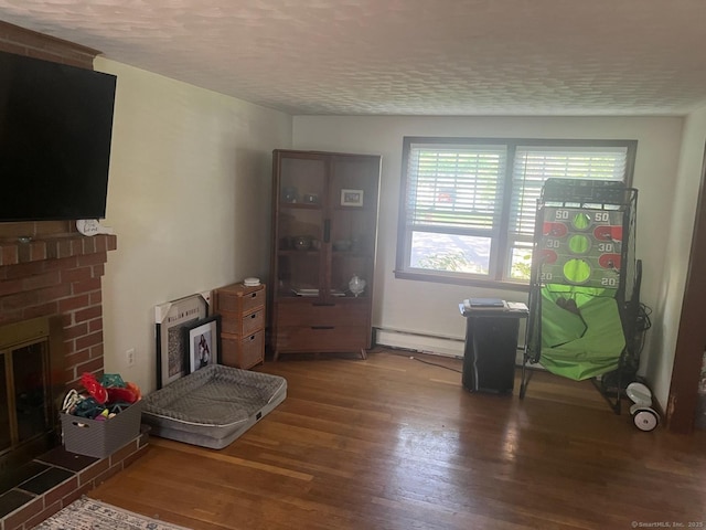 5 Hampton Rd, Enfield, CT 06082 - living room with baseboard heating, wood finished floors, a fireplace, and a textured ceiling