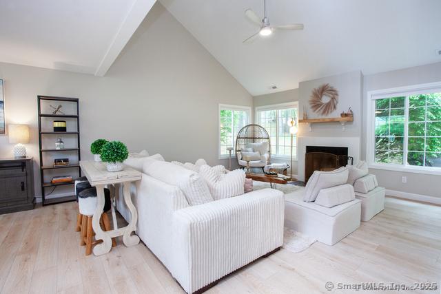 41 Stratton Forest Way, Simsbury, CT 06070 - living area featuring light wood finished floors, a ceiling fan, healthy amount of natural light, a fireplace, and high vaulted ceiling