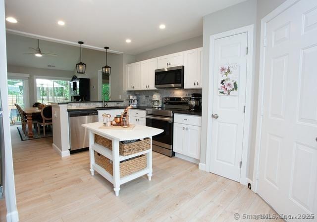 41 Stratton Forest Way, Simsbury, CT 06070 - kitchen with appliances with stainless steel finishes, a peninsula, backsplash, a ceiling fan, and light wood-style flooring