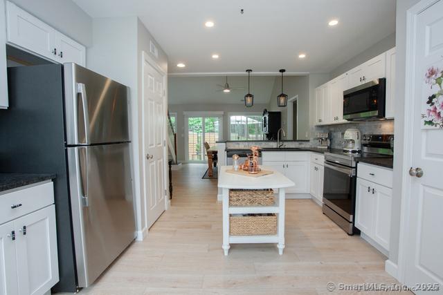 41 Stratton Forest Way, Simsbury, CT 06070 - kitchen featuring appliances with stainless steel finishes, a peninsula, backsplash, white cabinetry, and recessed lighting