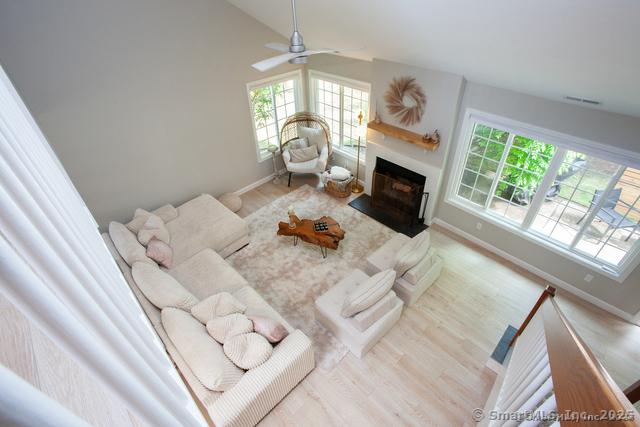 41 Stratton Forest Way, Simsbury, CT 06070 - living room with a fireplace with flush hearth, wood finished floors, baseboards, a ceiling fan, and vaulted ceiling