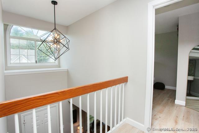 41 Stratton Forest Way, Simsbury, CT 06070 - staircase featuring wood finished floors, a chandelier, and baseboards