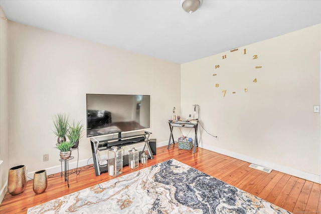 sitting room with baseboards, visible vents, and hardwood / wood-style flooring