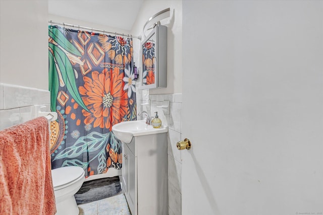 bathroom featuring vanity, toilet, tile walls, a wainscoted wall, and a shower with curtain