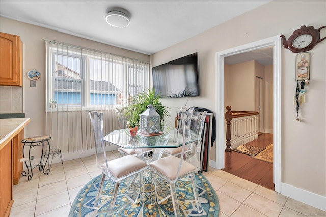 dining area featuring light tile patterned floors and baseboards