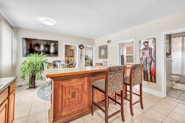bar with light tile patterned floors and baseboards