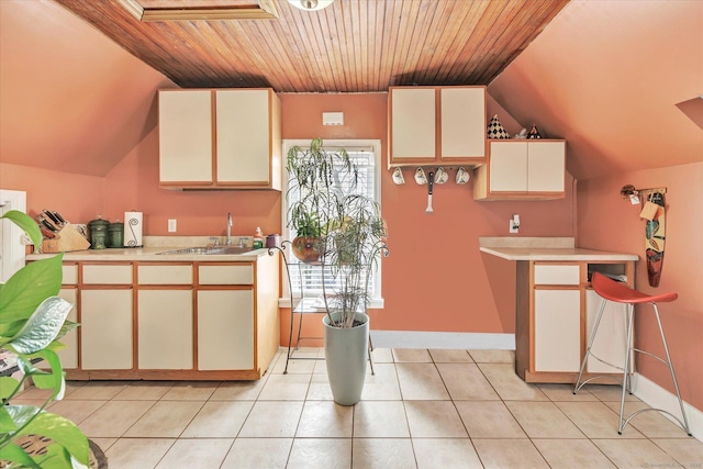 kitchen featuring light tile patterned flooring, light countertops, wood ceiling, a sink, and vaulted ceiling