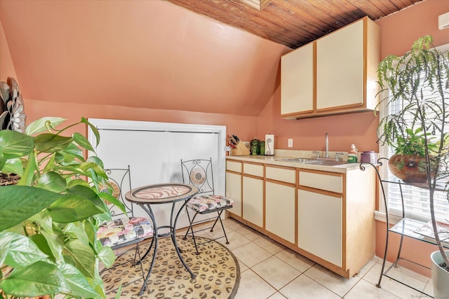 kitchen with a sink, light countertops, light tile patterned floors, lofted ceiling, and wood ceiling