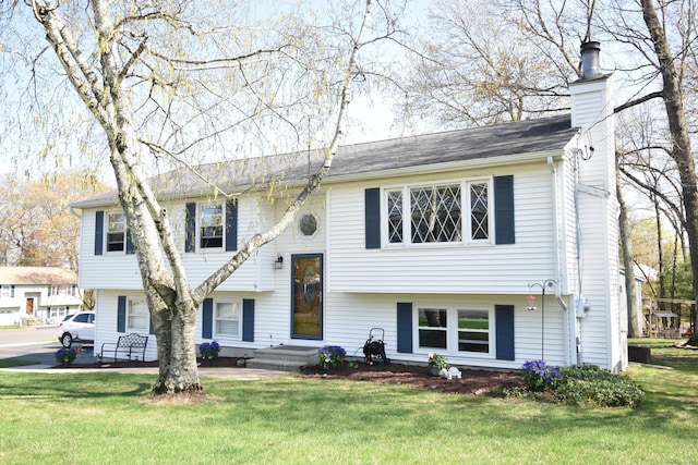 raised ranch with a chimney and a front yard