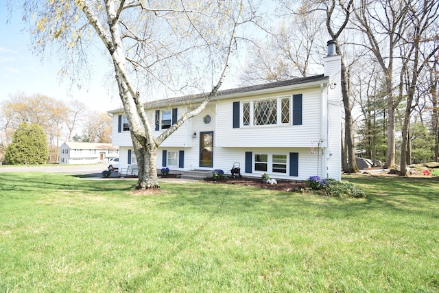bi-level home featuring a chimney and a front yard