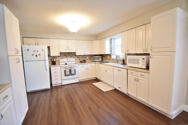 kitchen with dark wood-type flooring, white appliances, a sink, and under cabinet range hood