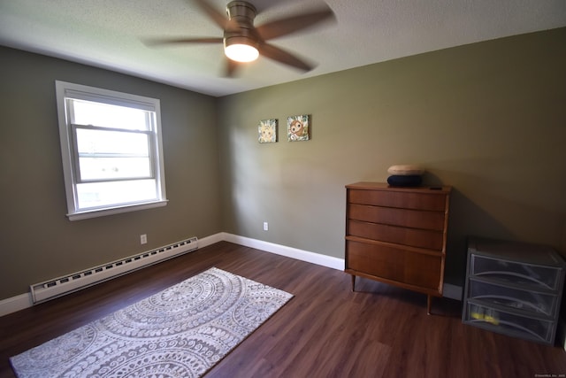 bedroom featuring a textured ceiling, a baseboard heating unit, baseboards, wood finished floors, and a ceiling fan