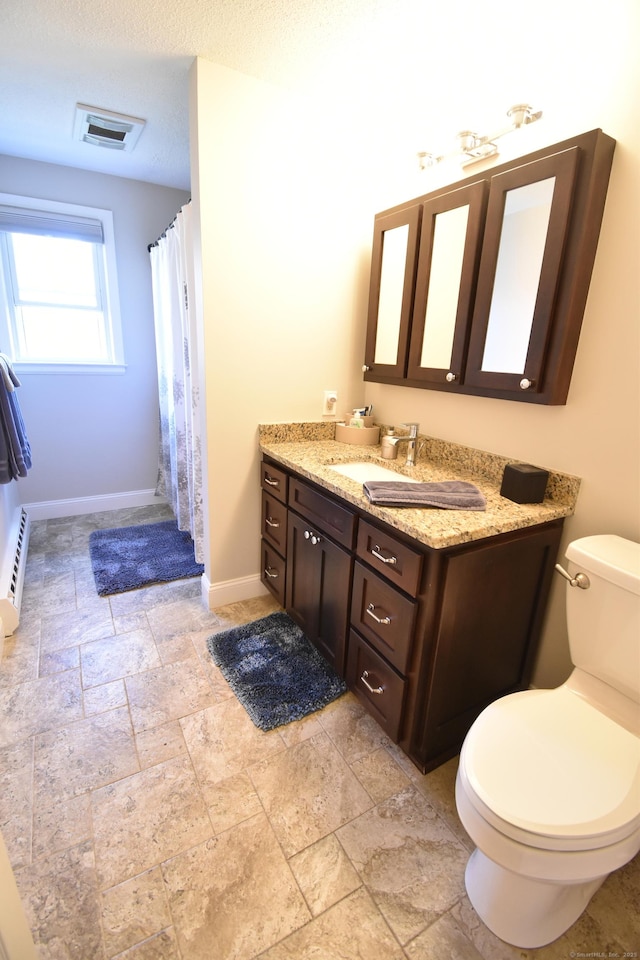 full bathroom featuring stone tile floors, visible vents, baseboards, toilet, and vanity