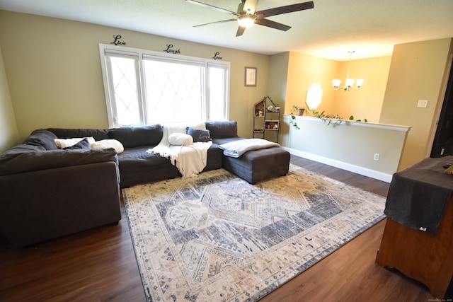 living room featuring wood finished floors, baseboards, and ceiling fan with notable chandelier