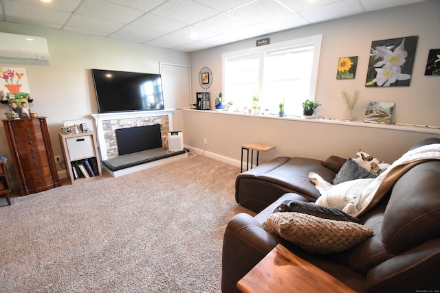 carpeted living room with baseboards, a wall unit AC, a fireplace, and a paneled ceiling