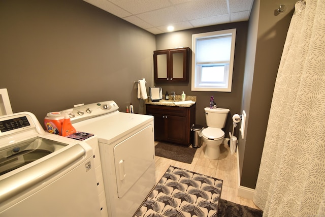 clothes washing area with separate washer and dryer, a sink, and laundry area