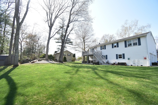 view of yard featuring an outdoor structure, a deck, stairs, and a shed