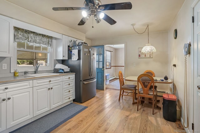 330 Flagler Ave, Stratford, CT 06614 - kitchen featuring a sink, light wood-type flooring, white cabinetry, and plenty of natural light
