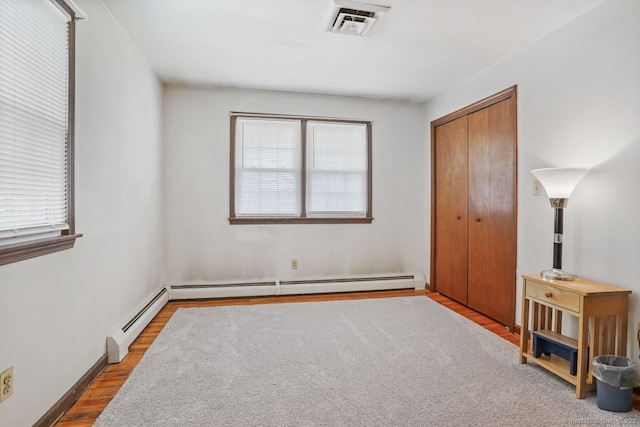 330 Flagler Ave, Stratford, CT 06614 - unfurnished bedroom featuring wood finished floors, multiple windows, a closet, and baseboard heating