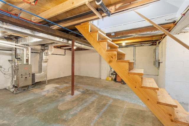unfinished below grade area featuring heating unit, stairs, and electric panel