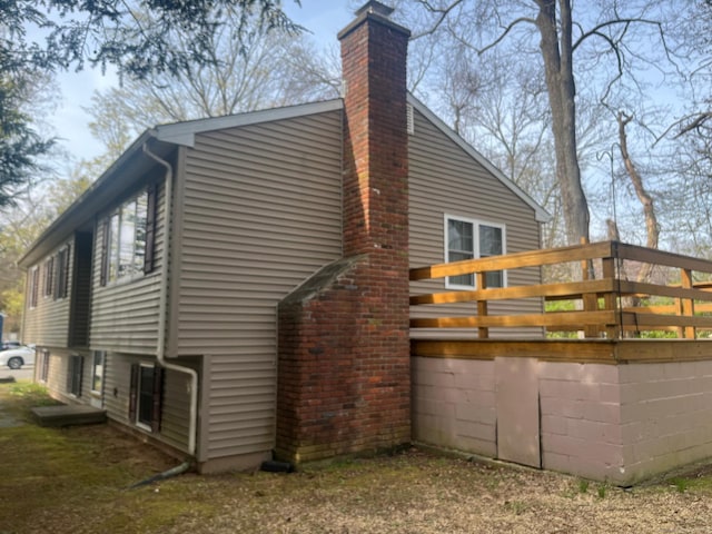 view of side of property with a chimney and a wooden deck
