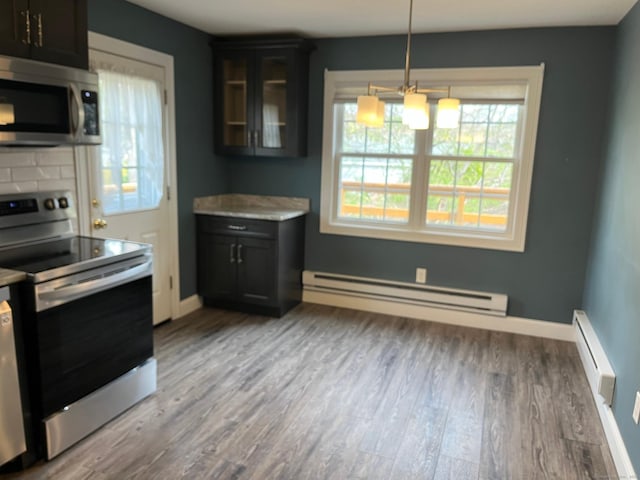 kitchen with baseboard heating, wood finished floors, appliances with stainless steel finishes, and a baseboard radiator