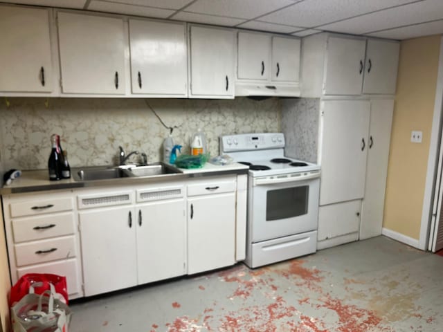 kitchen featuring a drop ceiling, white range with electric cooktop, under cabinet range hood, a sink, and concrete flooring