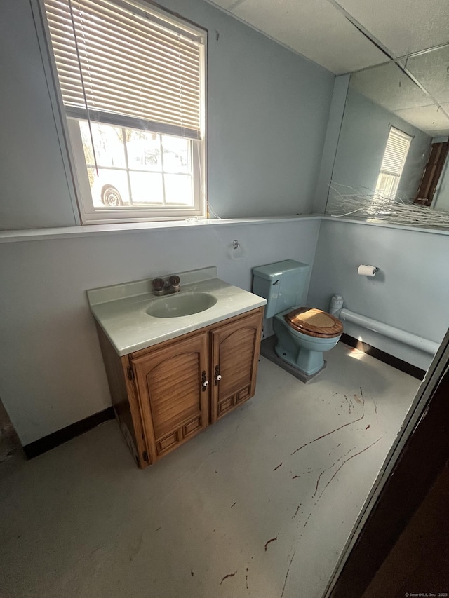 bathroom featuring baseboards, toilet, and vanity