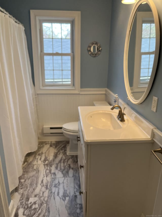 full bathroom with vanity, toilet, a wainscoted wall, marble finish floor, and baseboard heating