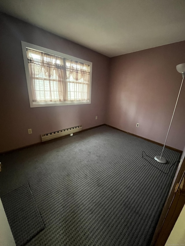 carpeted empty room with a baseboard radiator