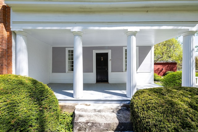 view of exterior entry featuring covered porch