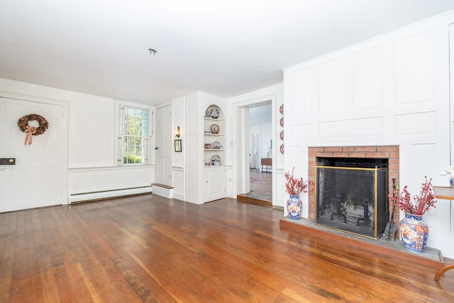 unfurnished living room with built in features, a baseboard radiator, a fireplace, and dark wood finished floors