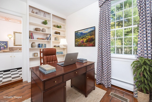 office area with visible vents, a baseboard radiator, a sink, and dark wood-type flooring