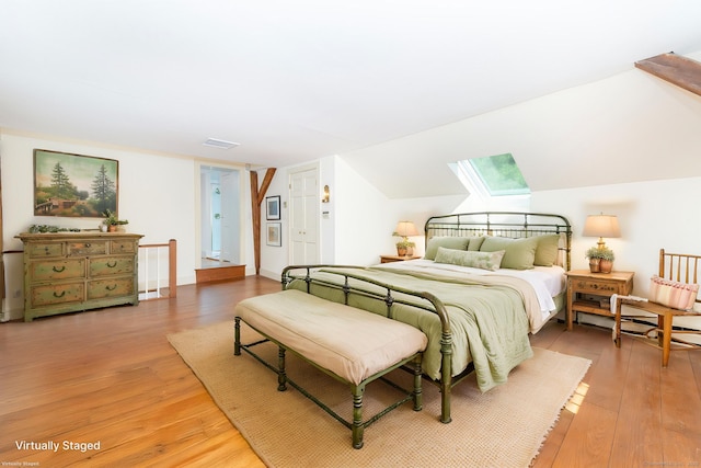 bedroom featuring visible vents, light wood finished floors, and a skylight